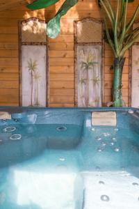 a hot tub in front of a house with palm trees at Ralph's Barn in Newport