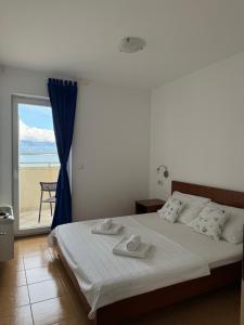 a bedroom with a bed with a view of the beach at Apartments & Restaurant Condura Croatica Nin-Sabunike in Nin