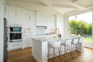 Una cocina con gabinetes blancos y una ventana grande. en Villa Summit Movie Theater Game room Views Hot Tub & Sauna, en La Conception