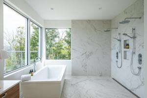 Un baño blanco con bañera y ducha. en Villa Summit Movie Theater Game room Views Hot Tub & Sauna, en La Conception 47 fotos más