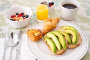 a plate of food with bread and apples and a bowl of fruit at The Stella Historic Llandudno Bed & Breakfast in Llandudno