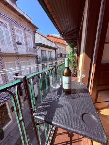 Una botella de vino sentada en una mesa en un balcón en Egas Duplex Historic Centre, en Guimarães