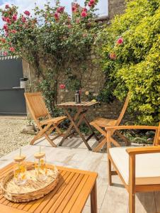 a patio with a table and chairs and roses at L'atelier au coeur de Meung in Meung-sur-Loire