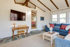 a living room with a blue couch and a table at Steps to Beaches and Main Street Hyannis Retreat in Hyannis