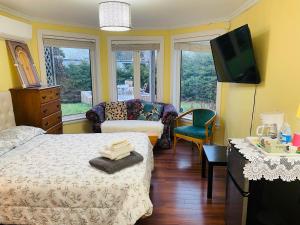a bedroom with a bed and a tv and a couch at Lily's garden in Charlottetown