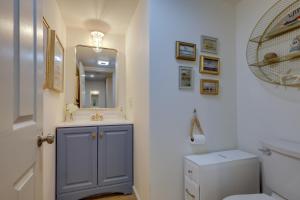 a bathroom with a sink and a toilet and a mirror at Steps to Beaches and Main Street Hyannis Retreat in Hyannis