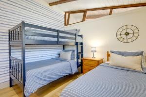 two beds in a bedroom with blue and white stripes at Steps to Beaches and Main Street Hyannis Retreat in Hyannis