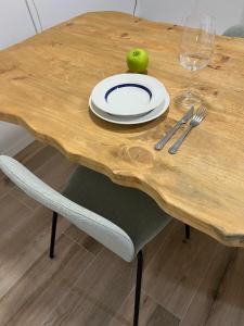 a wooden table with a plate and an apple on it at Blue rooms in Bilbao