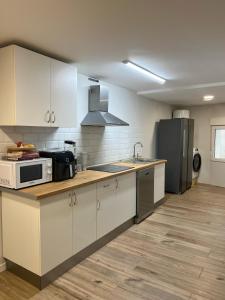 a kitchen with white cabinets and a microwave and a refrigerator at Blue Room 25 in Bilbao