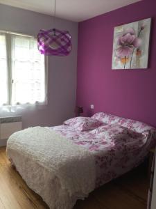 a bedroom with a bed and a purple wall at Totem Sud in Arcachon