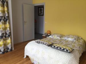 a bedroom with a bed and a yellow wall at Totem Sud in Arcachon +2 photos