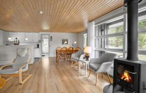 a living room with a fireplace and a dining room at Cozy Home In Aakirkeby With Wifi in Vester Sømarken