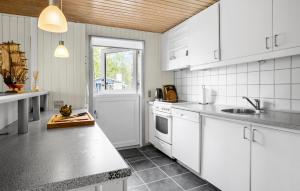 a kitchen with white cabinets and a counter top at Cozy Home In Aakirkeby With Wifi in Vester Sømarken