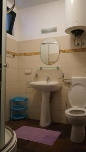 Un baño con lavabo, inodoro y espejo. en Lero Apartments, en Budva 72 fotos más