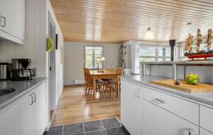 a kitchen with a table and a dining room at Cozy Home In Aakirkeby With Wifi in Vester Sømarken +15 photos