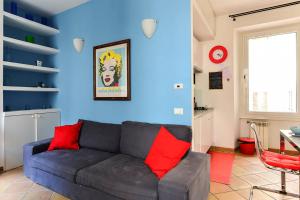 sala de estar con sofá y pared azul en Colosseo Luxury Apartment, en Roma