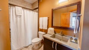 a bathroom with a toilet and a sink and a mirror at Avon Pier - 2-Bedroom, 2-Bathroom Suite at REAL Watersports in Waves +24 photos
