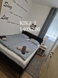 a bedroom with a bed with a sign on the wall at Kika apartmani-FREE PARKING- 7 km od centra in Zagreb