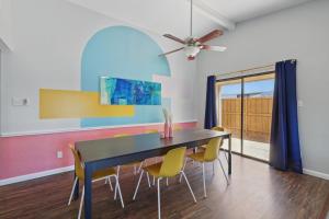 a dining room with a black table and yellow chairs at Modern & Chic 4BD,2BA - Pool, Hot Tub, BBQ Grill in Carrollton