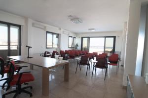 ein Esszimmer mit Tischen, Stühlen und Fenstern in der Unterkunft Hotel Acropolis in Cattolica