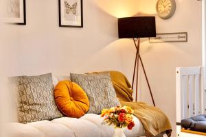 ein Wohnzimmer mit einer Couch und einer Uhr an der Wand in der Unterkunft Large One Bedroom Apartments Southsea Sleeps 3 - Free Parking in Portsmouth + 147 Fotos