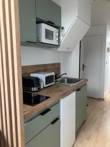 a kitchen with a sink and a microwave at Studio centre-ville climatisé avec parking gratuit in Clermont-Ferrand