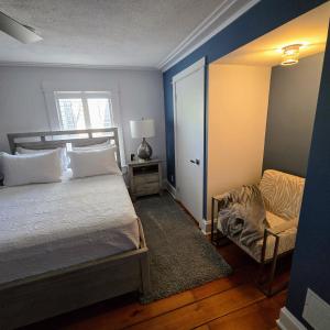 a bedroom with a bed and a chair and a window at The Royal Manor Inn in Niagara-on-the-Lake +93 photos