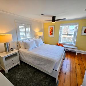 a bedroom with a white bed and two windows at The Royal Manor Inn in Niagara-on-the-Lake