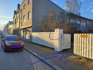 a car parked next to a fence next to a building at Huoneisto Pikku Neristan in Kokkola +2 photos