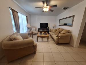 a living room with two couches and a ceiling fan at Home 3 beds 1 full bath 1 half bath Port Charlotte near beach in Port Charlotte