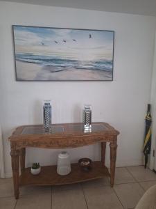 a wooden table in a room with a painting on the wall at Home 3 beds 1 full bath 1 half bath Port Charlotte near beach in Port Charlotte
