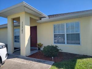 a house with a car parked in front of it at Home 3 beds 1 full bath 1 half bath Port Charlotte near beach in Port Charlotte