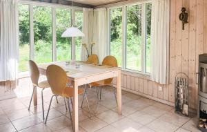 ein Tisch und Stühle in einer Küche mit Fenstern in der Unterkunft 3 Bedroom Cozy Home In Fårevejle in Fårevejle