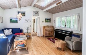 ein Wohnzimmer mit einem blauen Sofa und einem Klavier in der Unterkunft 3 Bedroom Cozy Home In Fårevejle in Fårevejle