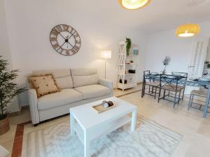 ein Wohnzimmer mit Sofa und Tisch in der Unterkunft Apartamento La Noria pie de playa Manilva in San Luis de Sabinillas