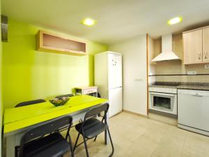 a small kitchen with a yellow table and chairs at Apartamento con terraza en Playa Grau de Moncofa in Moncófar +16 photos