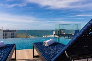 a view of a swimming pool with a bench and the ocean at Ingleses Park Hotel in Florianópolis