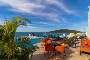 a patio with tables and chairs and the ocean at Ingleses Park Hotel in Florianópolis