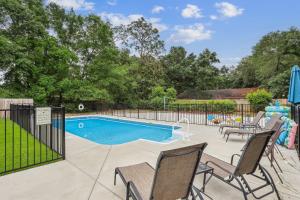 a swimming pool in a yard with chairs and a fence at 2967 Swan Lane in Pensacola