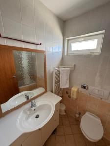 a bathroom with a sink and a toilet and a mirror at Apartments & Restaurant Condura Croatica Nin-Sabunike in Nin +59 photos