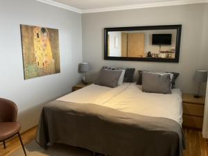una camera da letto con un letto con specchio e una sedia di A. Bernhard Guest House a Keflavík