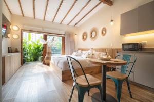 a bedroom with a bed and a table with chairs at Candelaria Aparta Hotel Boutique in Medellín