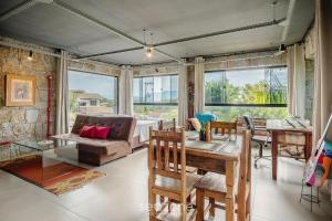 a living room with a table and a couch at Estúdios completos na Praia de Imbituba - PRN in Praia do Rosa