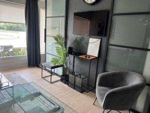a living room with a chair and a clock on the wall at 2 bedroom apartment at Knokke-Heist, near Zeebrugge, overlooking the lake in Knokke-Heist