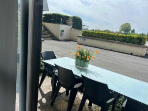 a blue table with a vase of flowers on it at 2 bedroom apartment at Knokke-Heist, near Zeebrugge, overlooking the lake in Knokke-Heist