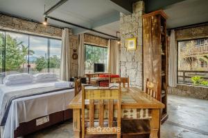 a bedroom with a bed and a table and chairs at Estúdios completos na Praia de Imbituba - PRN in Praia do Rosa
