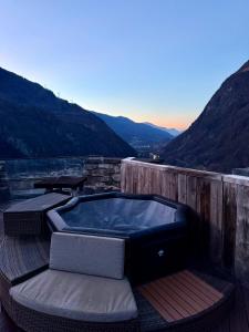 a hot tub on a deck with a view of a mountain at La tour du Château - Jacuzzi sur le toit in La Léchère