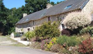 an old stone house with a garden in front of it at Gîte Kersonan in Saint-Jean-Brévelay