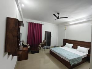 a bedroom with a bed and a red curtain at Rema Guest House in Itānagar