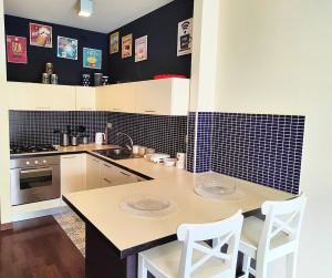 a kitchen with a table and two white chairs at Bluemar Dolcemare - 105mq in Cattolica